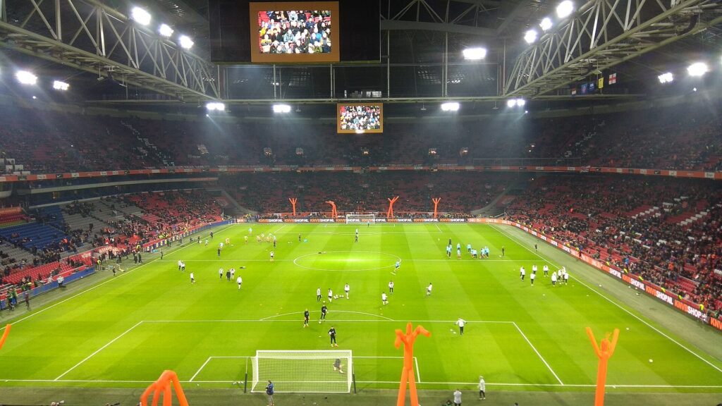 Wnętrze stadionu Johan Cruijff ArenA w Amsterdamie z oświetloną murawą